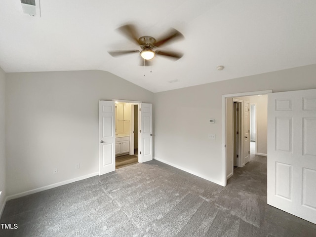 unfurnished bedroom featuring vaulted ceiling, dark colored carpet, and ceiling fan