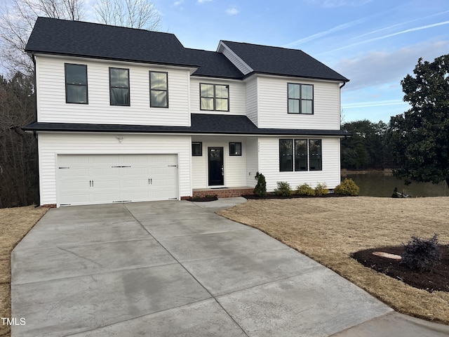 modern inspired farmhouse featuring an attached garage, concrete driveway, and roof with shingles