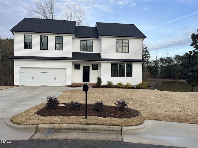 view of front facade with roof with shingles, driveway, and an attached garage