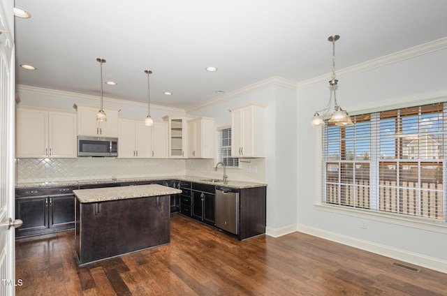 kitchen with sink, decorative light fixtures, a center island, and appliances with stainless steel finishes