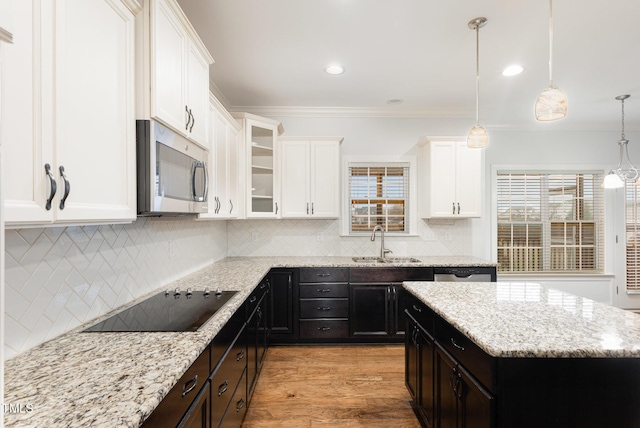 kitchen featuring white cabinetry, black electric stovetop, sink, and a center island