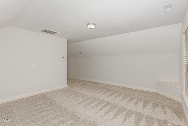 additional living space with carpet floors and vaulted ceiling