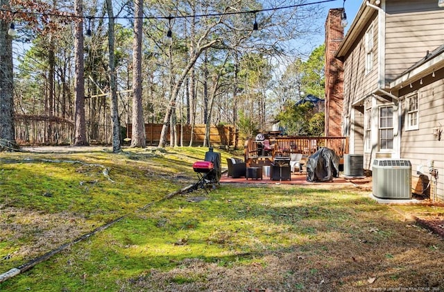 view of yard with a wooden deck and central air condition unit