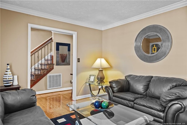 living room with crown molding, wood-type flooring, and a textured ceiling