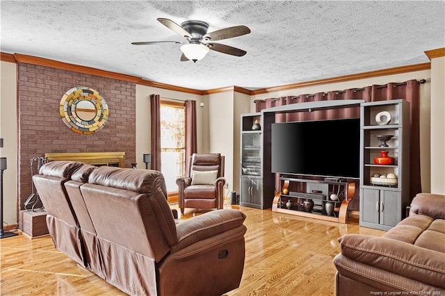 living room with crown molding, ceiling fan, a textured ceiling, and light wood-type flooring