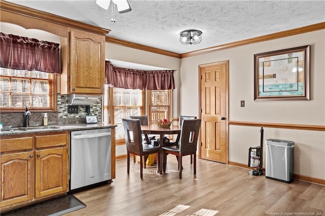 kitchen with crown molding, stainless steel dishwasher, plenty of natural light, and sink