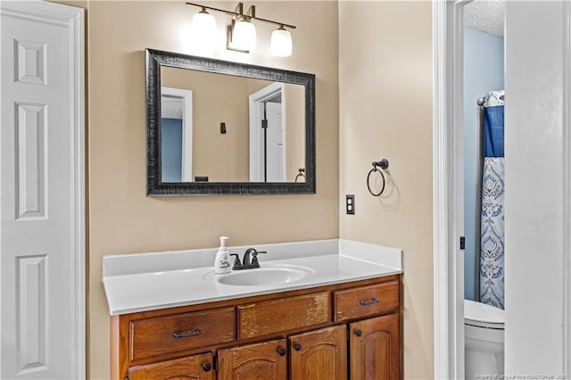 bathroom with vanity, a textured ceiling, and toilet