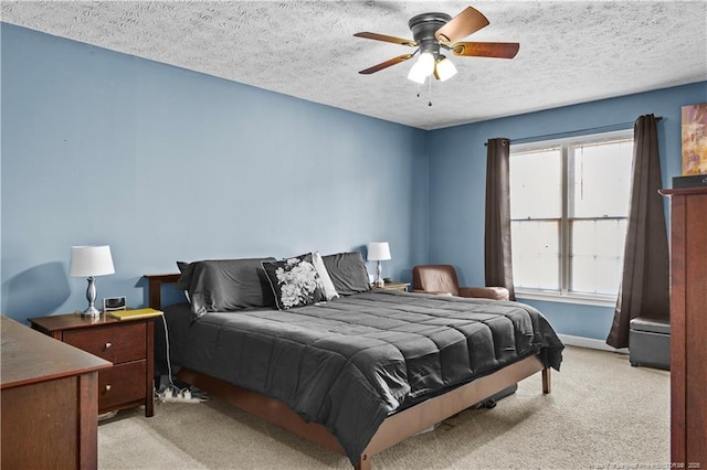 carpeted bedroom featuring ceiling fan and a textured ceiling