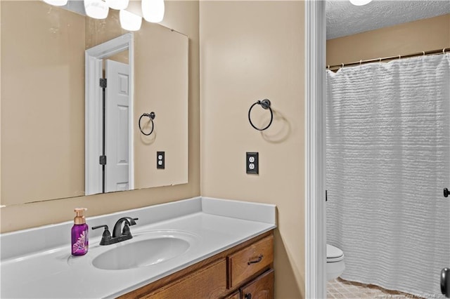 bathroom with vanity, a textured ceiling, and toilet