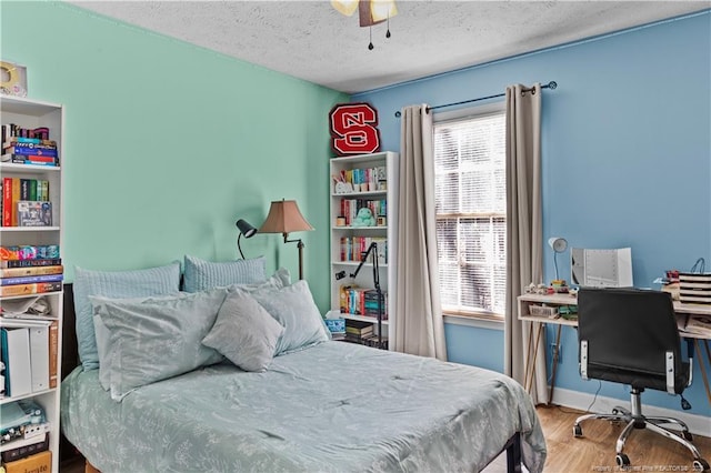 bedroom with wood-type flooring and a textured ceiling