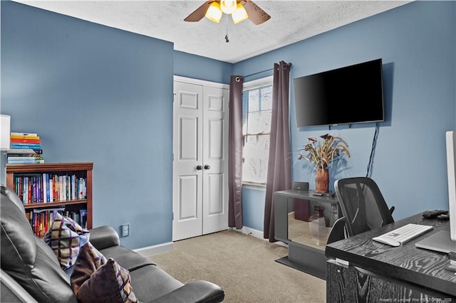 home office featuring ceiling fan, light colored carpet, and a textured ceiling