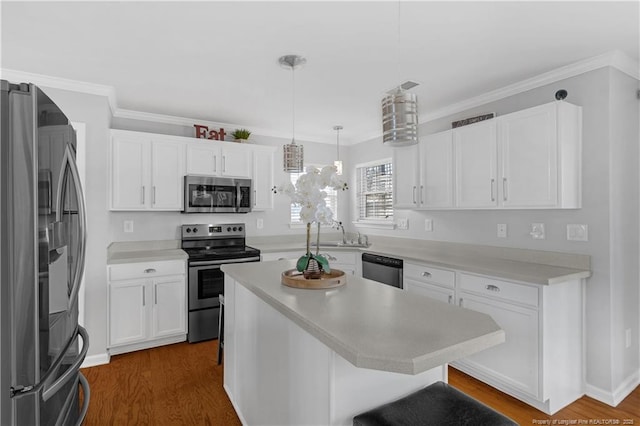 kitchen featuring a breakfast bar, white cabinetry, a center island, appliances with stainless steel finishes, and pendant lighting