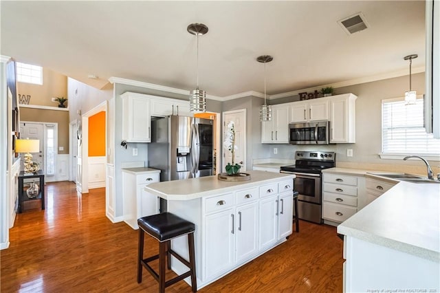 kitchen featuring sink, white cabinetry, a center island, pendant lighting, and stainless steel appliances