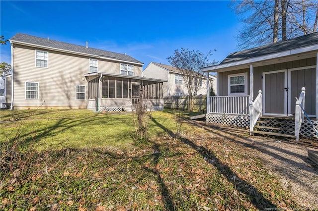 rear view of property with a lawn and a sunroom