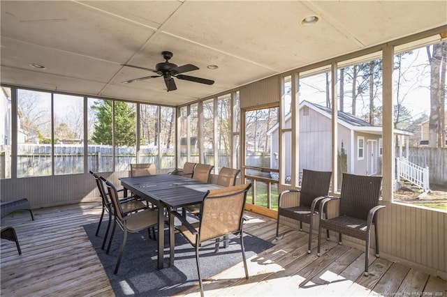 sunroom featuring a water view and ceiling fan