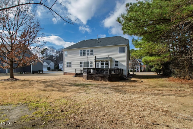 rear view of property featuring a lawn and a deck