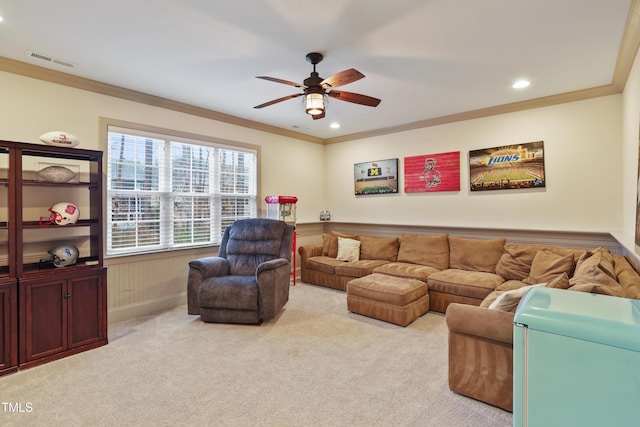 carpeted living room featuring ornamental molding and ceiling fan