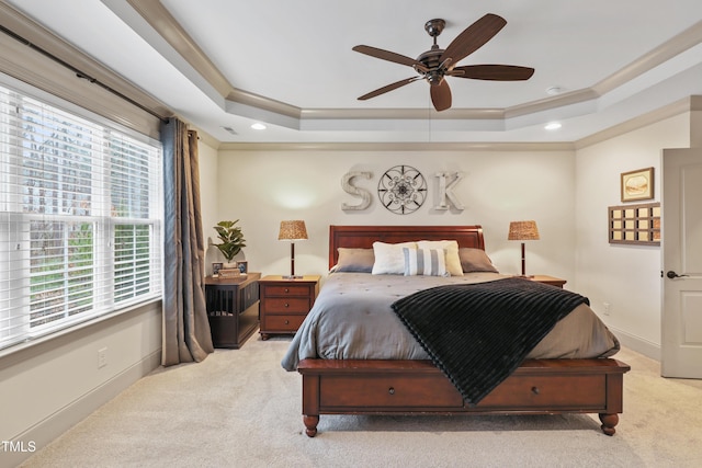 bedroom featuring light carpet, crown molding, a raised ceiling, and ceiling fan