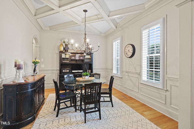 dining room with coffered ceiling, a chandelier, beam ceiling, and light hardwood / wood-style floors