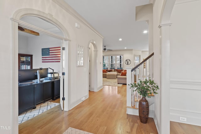 foyer featuring hardwood / wood-style floors, crown molding, ceiling fan, and ornate columns