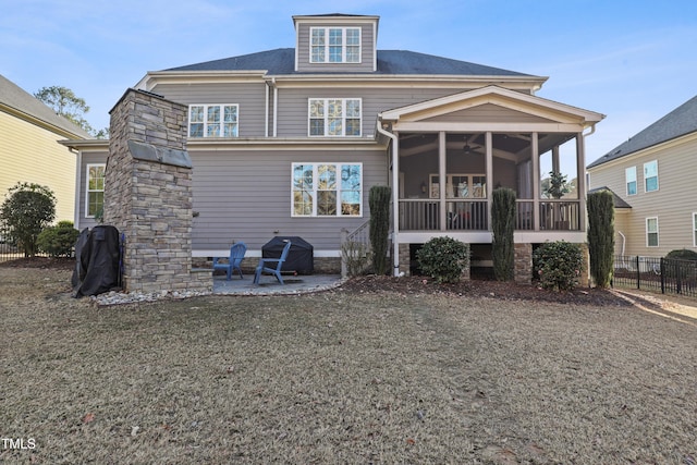 rear view of house featuring a sunroom, a yard, ceiling fan, and a patio area