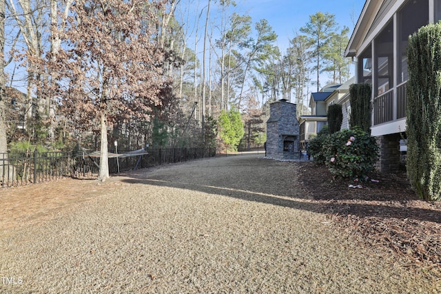 view of gate with an outdoor stone fireplace