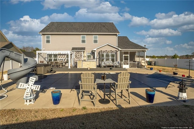 rear view of house with a patio area, a hot tub, a pergola, exterior bar, and a sunroom