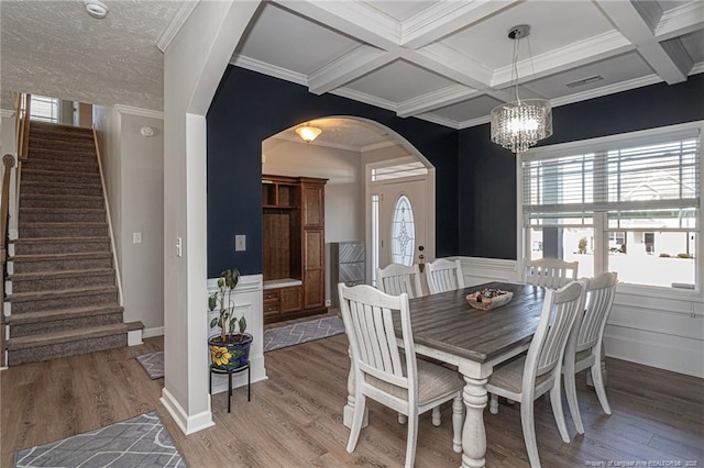 dining room with beamed ceiling, crown molding, coffered ceiling, and hardwood / wood-style floors