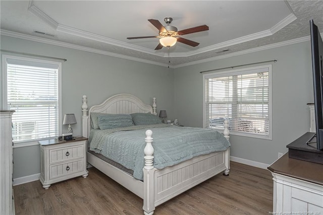 bedroom with multiple windows, crown molding, dark wood-type flooring, and ceiling fan