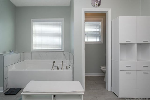 bathroom with a bath, tile patterned floors, and toilet