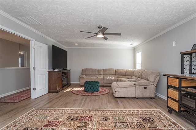 living room with ornamental molding, a textured ceiling, ceiling fan, and light hardwood / wood-style flooring