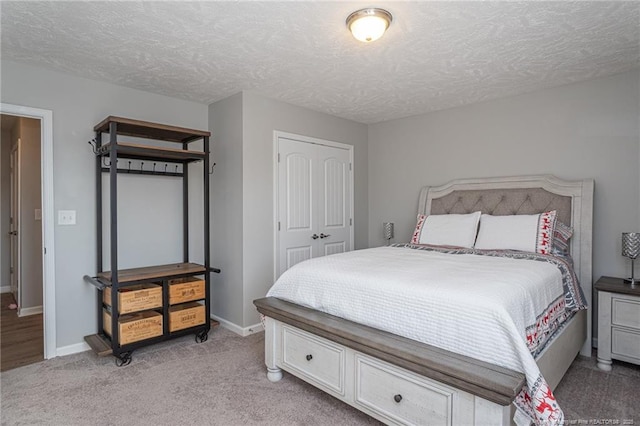 carpeted bedroom featuring a closet and a textured ceiling