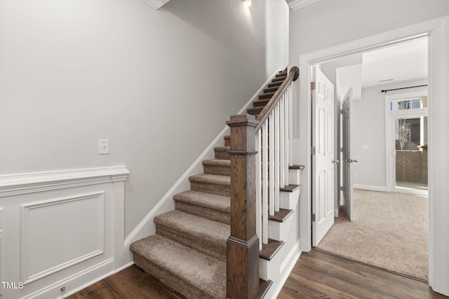 stairway with baseboards, wood finished floors, and carpet flooring