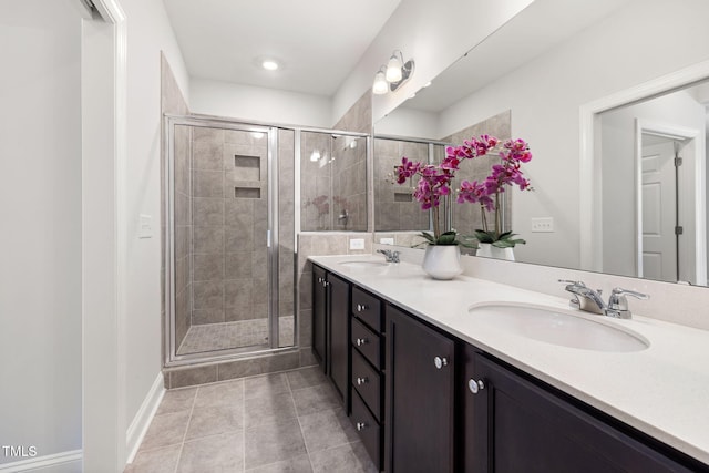 bathroom featuring a stall shower, a sink, and double vanity