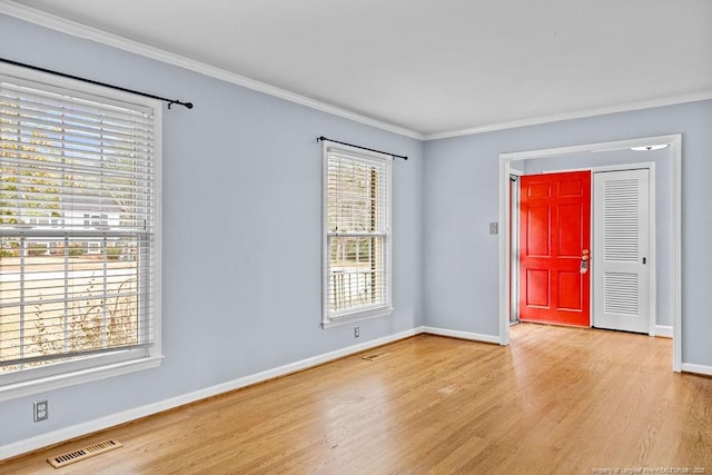 entrance foyer featuring ornamental molding and light hardwood / wood-style floors