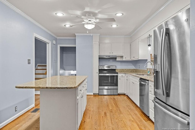 kitchen featuring light stone counters, a kitchen island, white cabinets, and appliances with stainless steel finishes