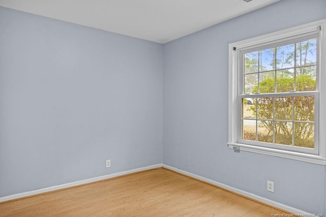 empty room with light hardwood / wood-style floors and a healthy amount of sunlight