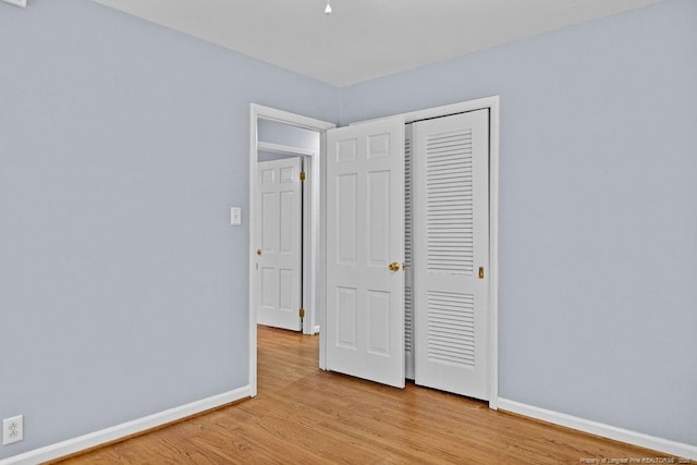 unfurnished bedroom with light hardwood / wood-style floors and a closet