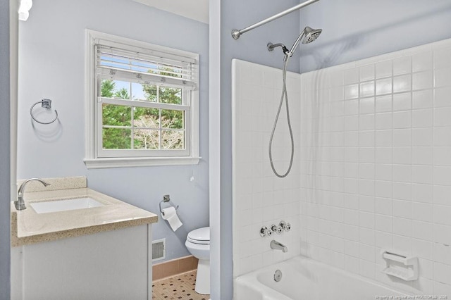 full bathroom featuring vanity, toilet, tiled shower / bath combo, and tile patterned flooring