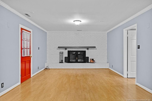 unfurnished living room with crown molding, hardwood / wood-style floors, and a brick fireplace