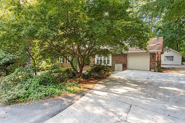 view of property hidden behind natural elements with a garage