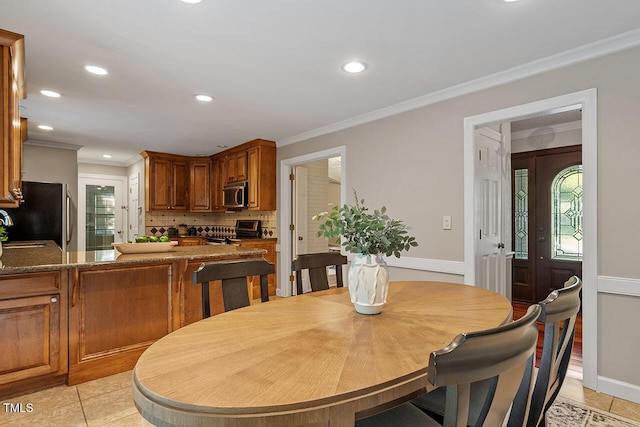 dining area with ornamental molding, a healthy amount of sunlight, and light tile patterned floors