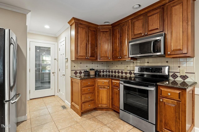 kitchen featuring light tile patterned flooring, decorative backsplash, dark stone counters, stainless steel appliances, and crown molding