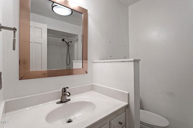 bathroom featuring vanity, walk in shower, and toilet