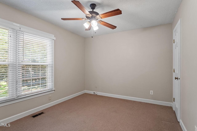 carpeted empty room with ceiling fan and a textured ceiling