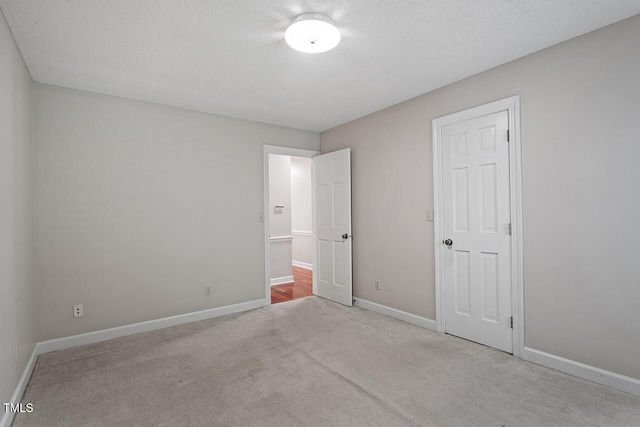 unfurnished bedroom featuring light colored carpet and a textured ceiling