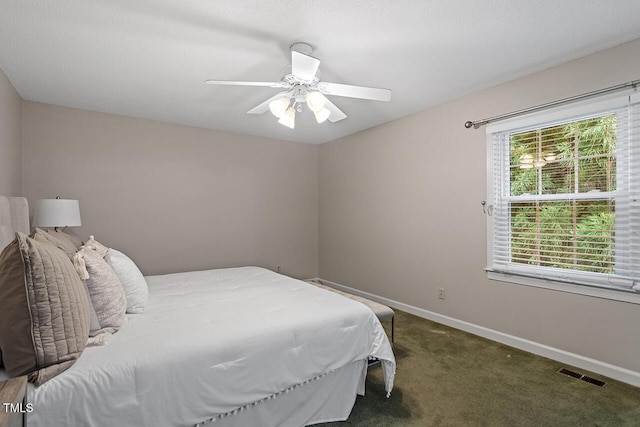 bedroom with ceiling fan and dark carpet