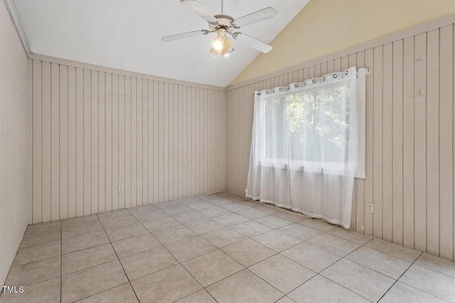 tiled spare room featuring vaulted ceiling and ceiling fan