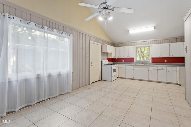 kitchen with white gas range, sink, light tile patterned floors, and white cabinets