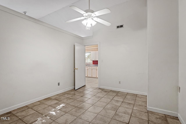 empty room with ceiling fan and light tile patterned flooring